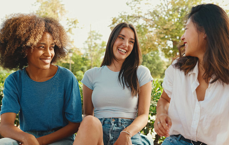 three smiling women sitting outside, addiction treatment san diego,