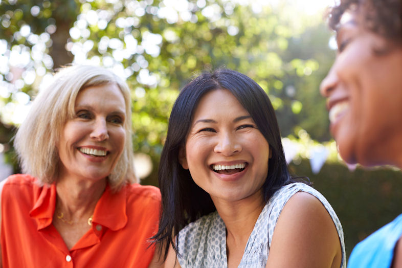 three women outside smiling together