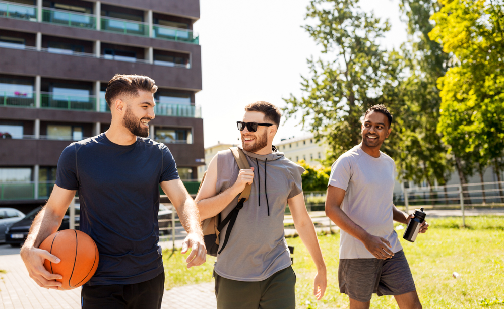 three men outside with athletic equipment