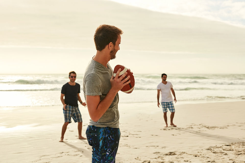 men playing football on a Californian beach