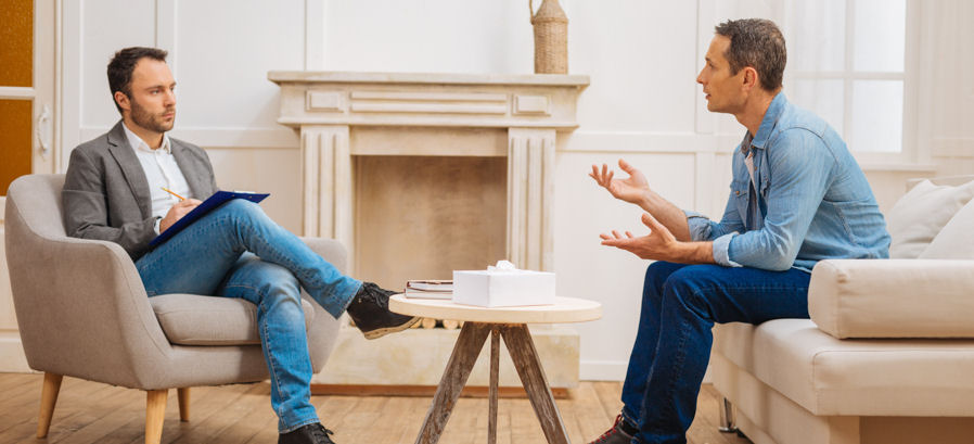 man speaking in small group therapy session