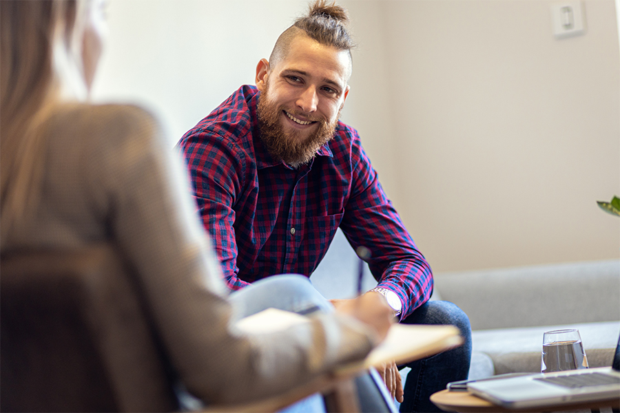 man smiling at counselor in individual therapy