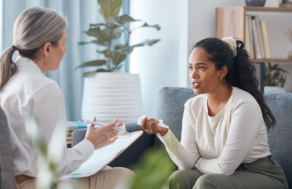 cognitive-behavioral-therapy-for-addiction Woman with white scrunchie in CBT session with older therapist
