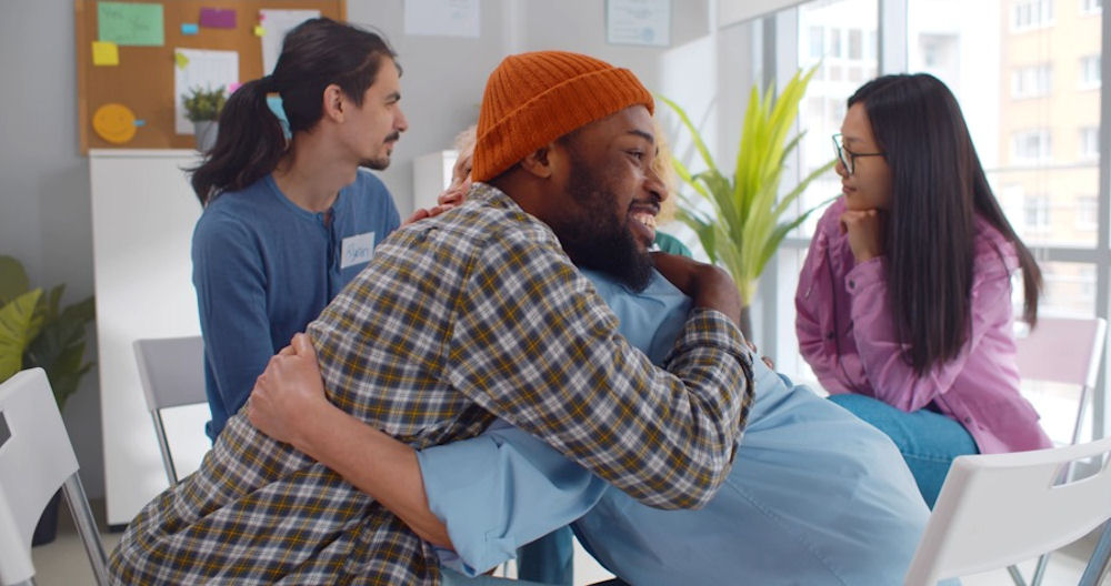 Man embraces woman in addiction support group, emdr for addiction treatment, EMDR for addiction recovery
