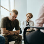 Man in fatigues speaking while leadining down in depression support group, depression and addiction treatment, depression