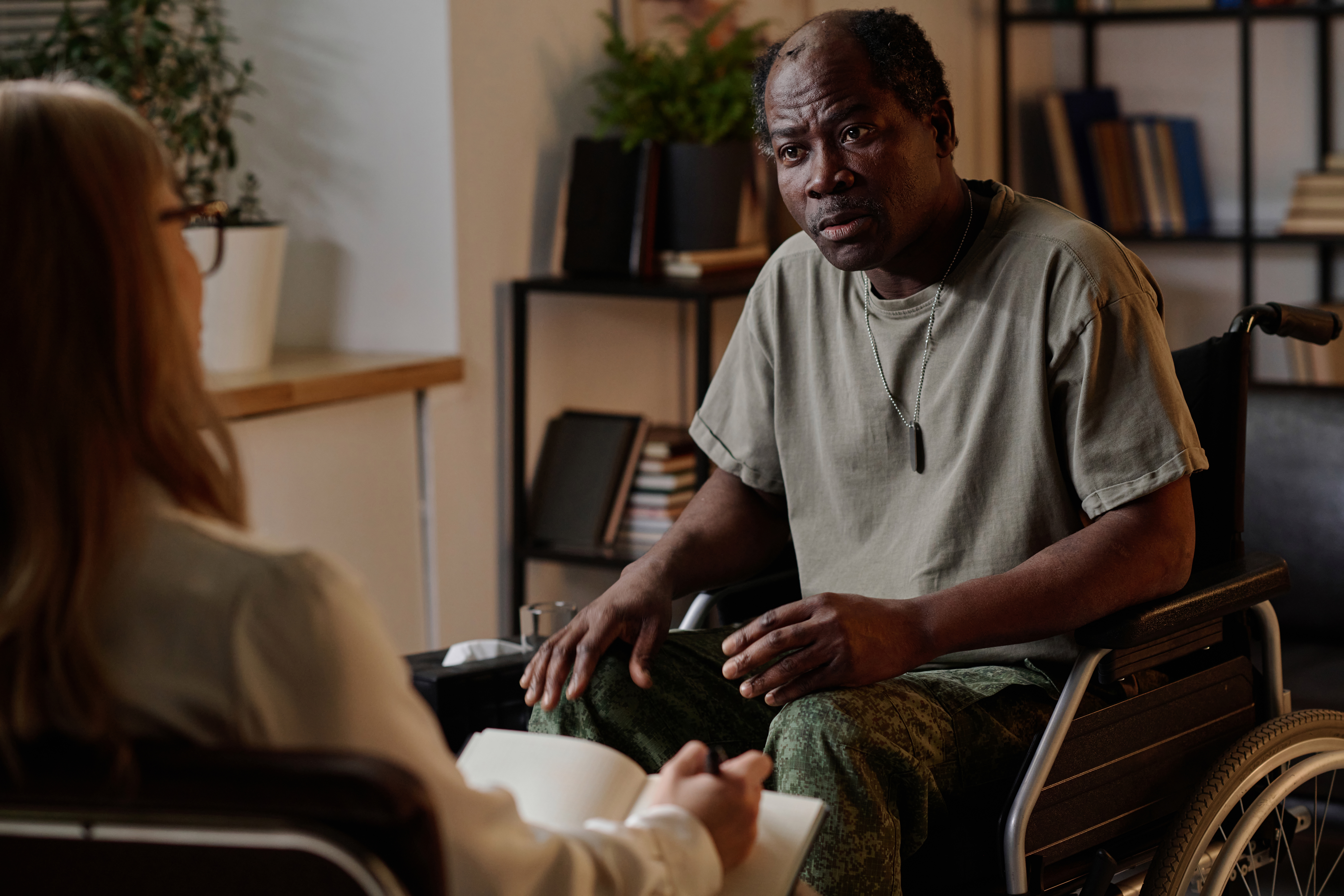 Mature African American Soldier in Wheelchair Listening to Psychologist addiction treatment FAQ