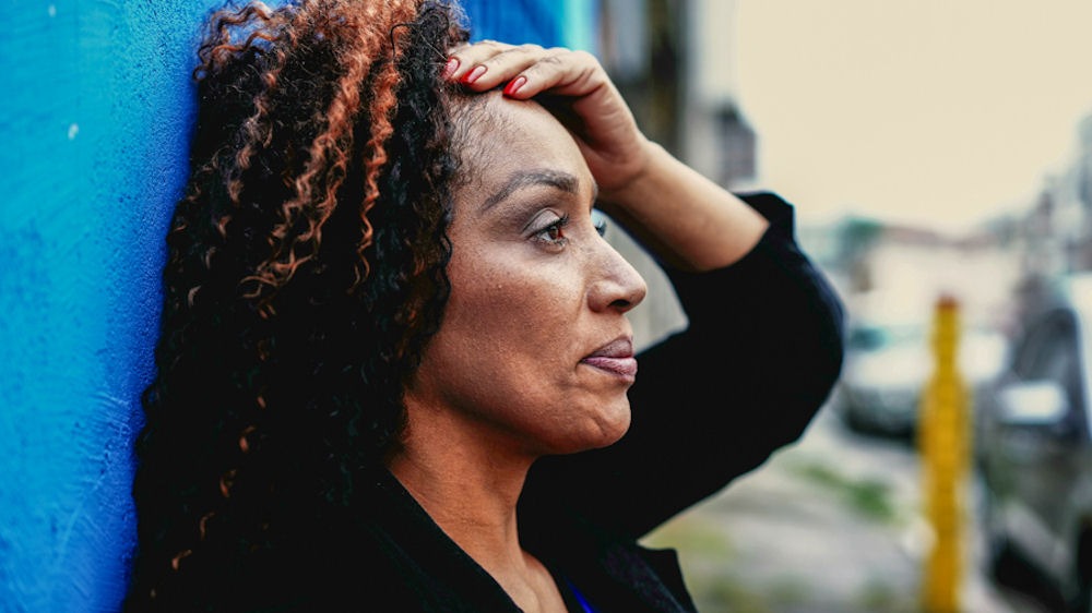 treatment-prescription-drug-addiction Sad woman leaning back on wall and holding her head, prescription drug addiction treatment,